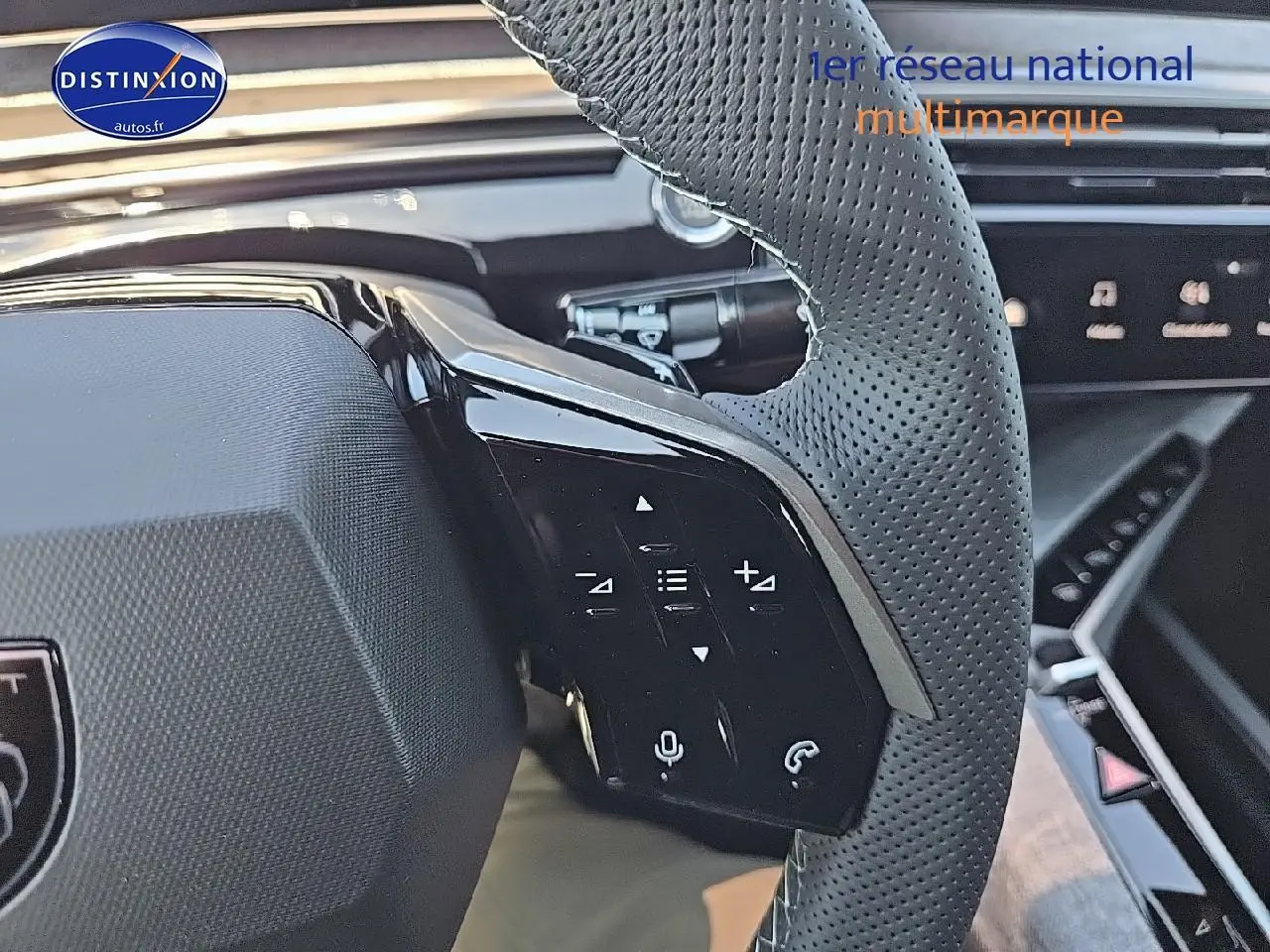 Gros plan sur le volant cuir perforé côté gauche du Peugeot 3008 noir hybride avec commandes multifonctions intégrées.