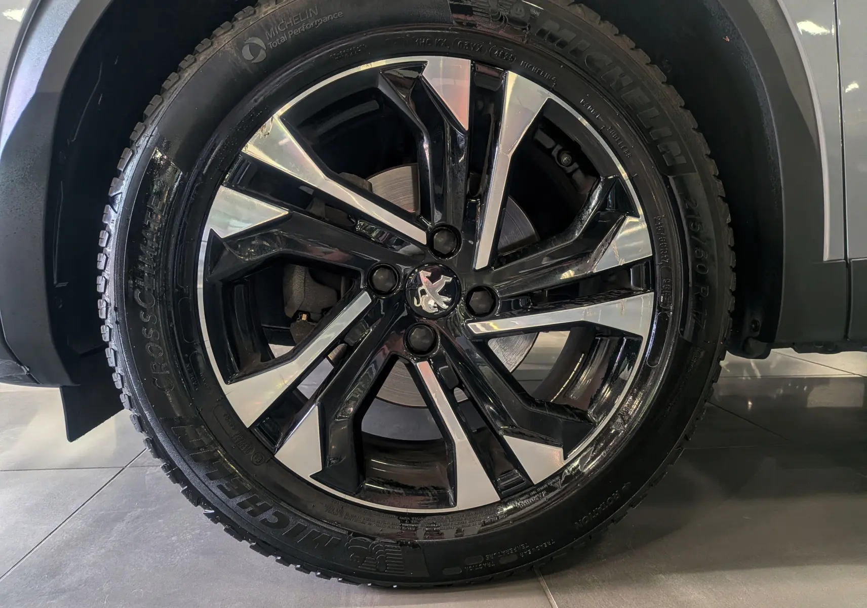 Gros plan sur la jante alliage bicolore noire et argent du Peugeot 2008 Gris Artense, avec pneu Michelin visible.