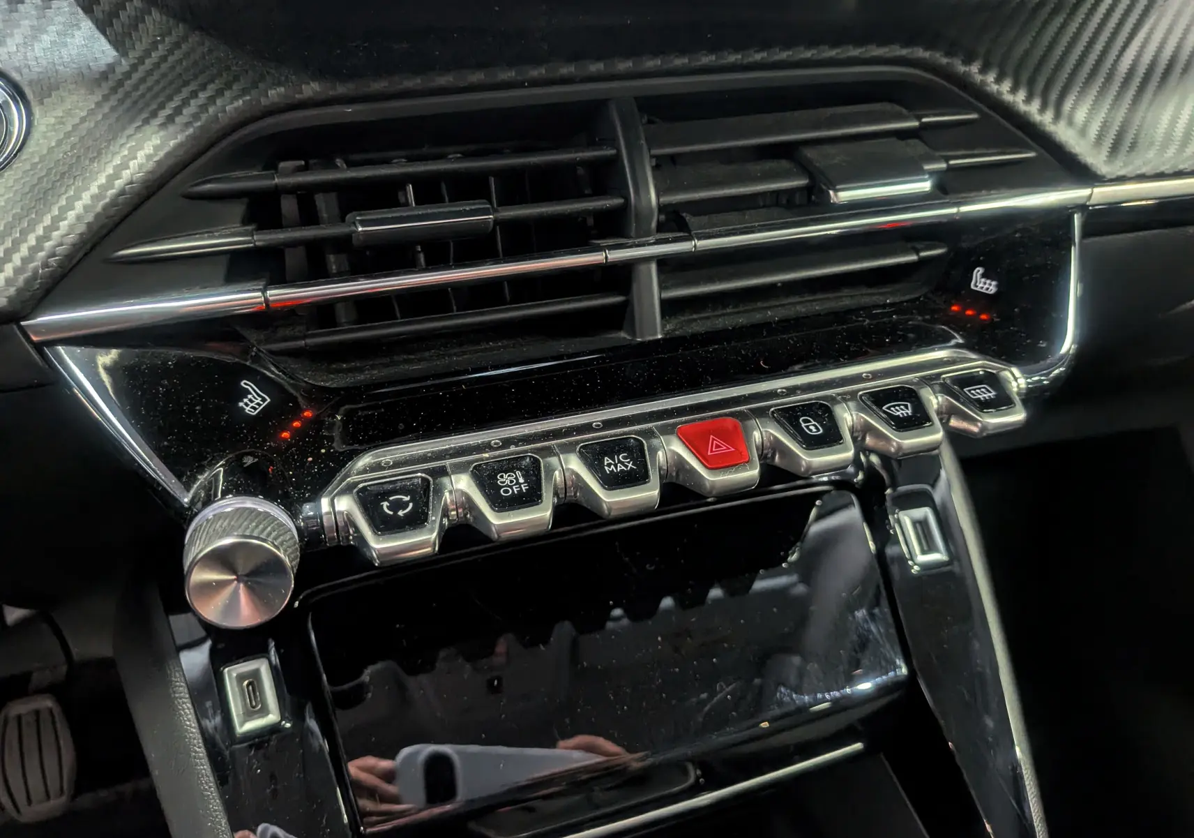 Vue rapprochée de la console centrale noire brillante avec commandes et aérateurs du Peugeot 2008 Gris Artense 2021.