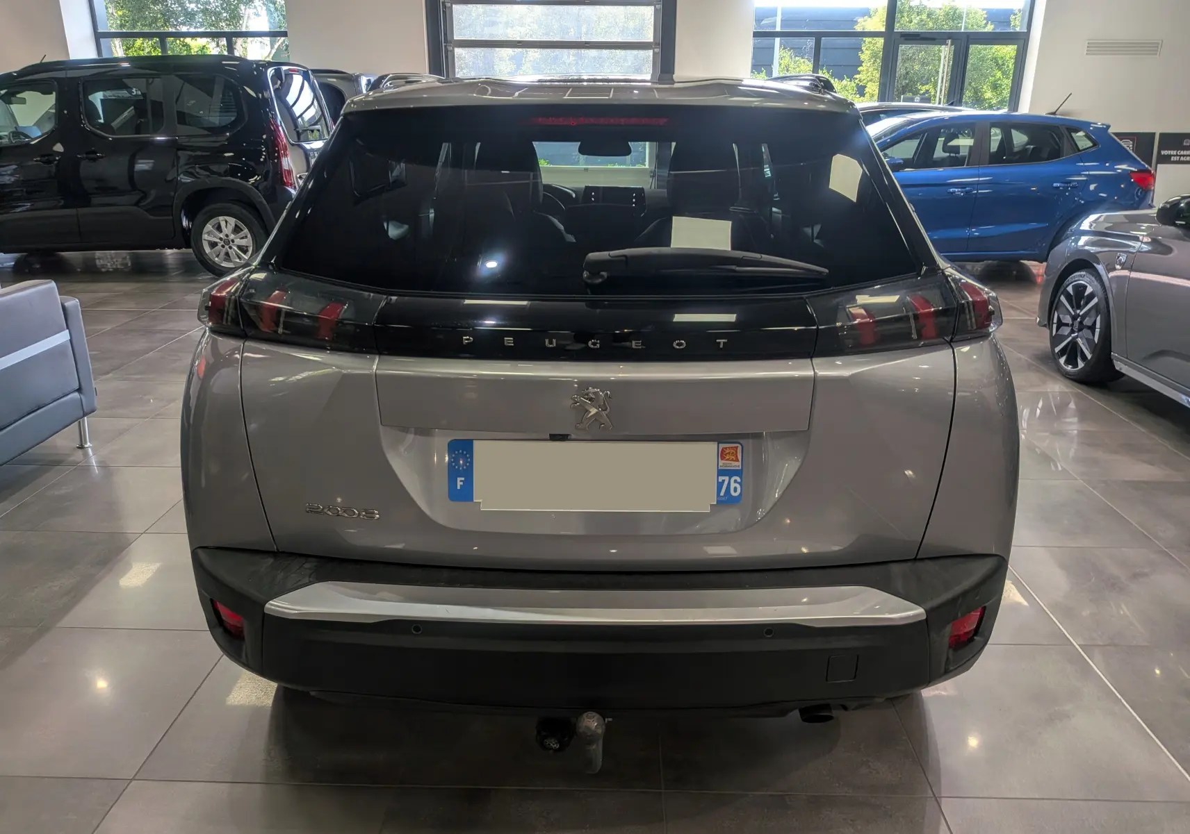 Vue arrière d'un Peugeot 2008 Gris Artense 2021 avec hayon noir brillant et feux arrière en forme de griffes.