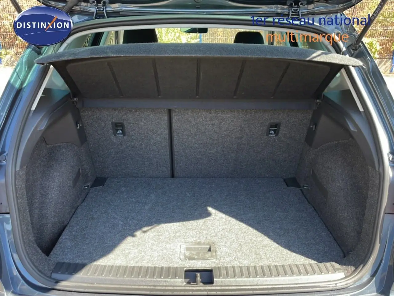 Coffre ouvert vu de l'arrière d'un SEAT Arona gris Magnetic Metal avec toit noir, intérieur du coffre en tissu gris.