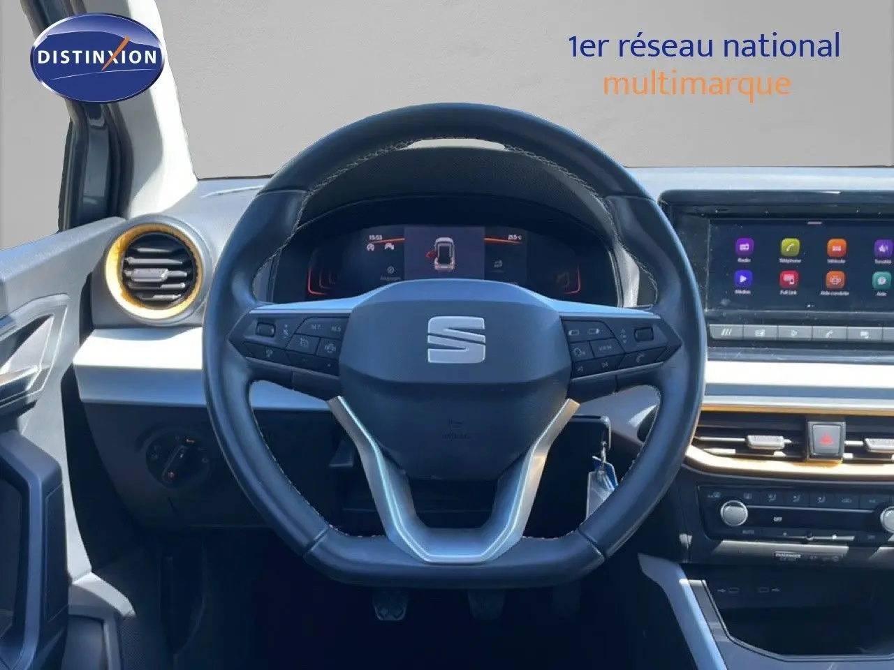 Vue frontale du poste de conduite du SEAT Arona gris magnetic metal avec volant multifonction et écran tactile central.