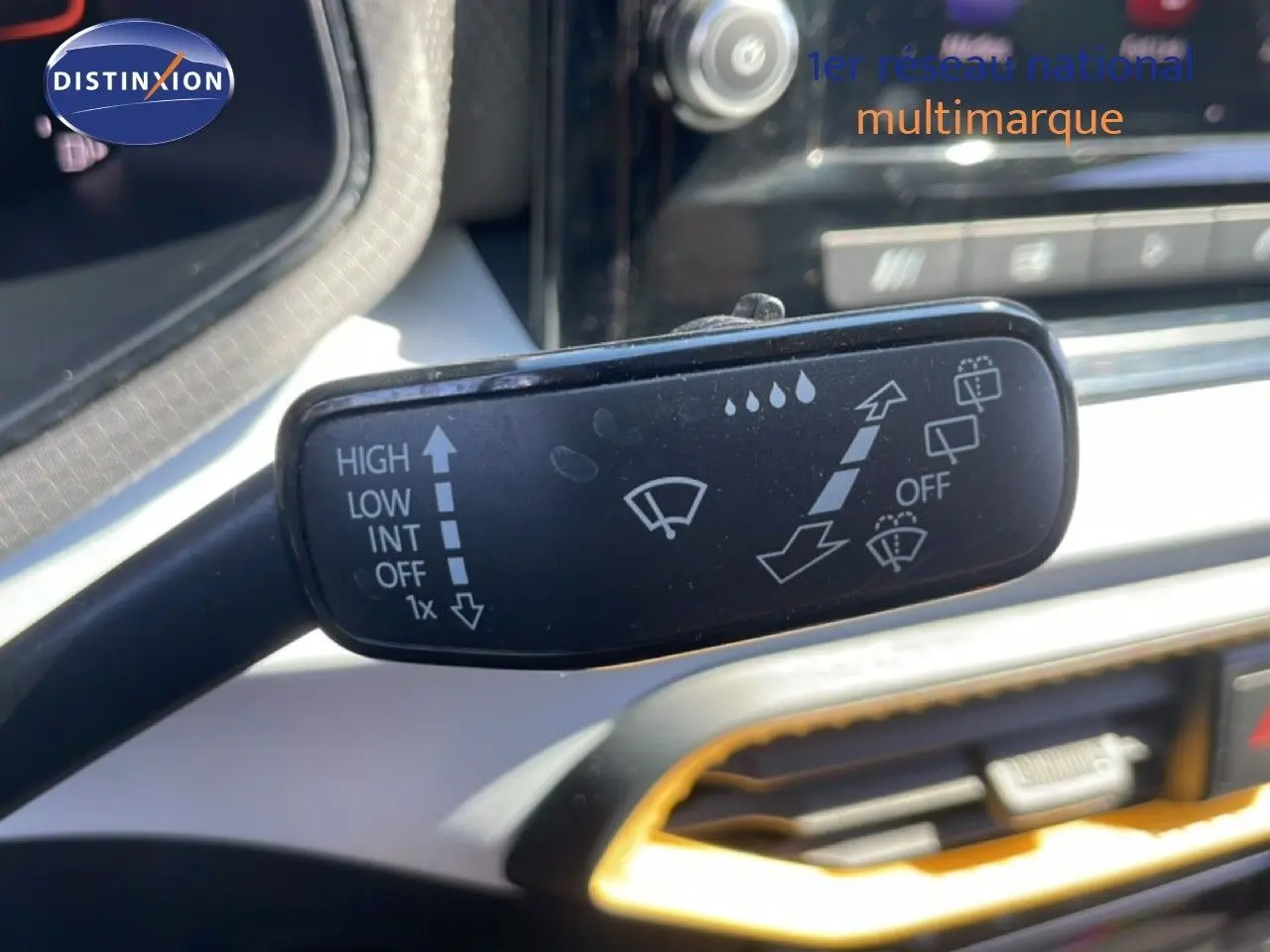 Gros plan sur la commande d’essuie-glace dans l’habitacle gris noir du SEAT Arona 2025, toit noir visible en arrière-plan.