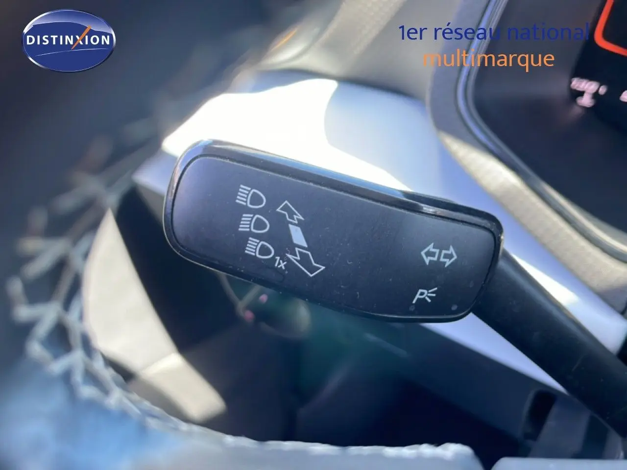 Gros plan sur la commande de clignotants et feux du SEAT Arona 2025, intérieur gris et noir visible en arrière-plan.