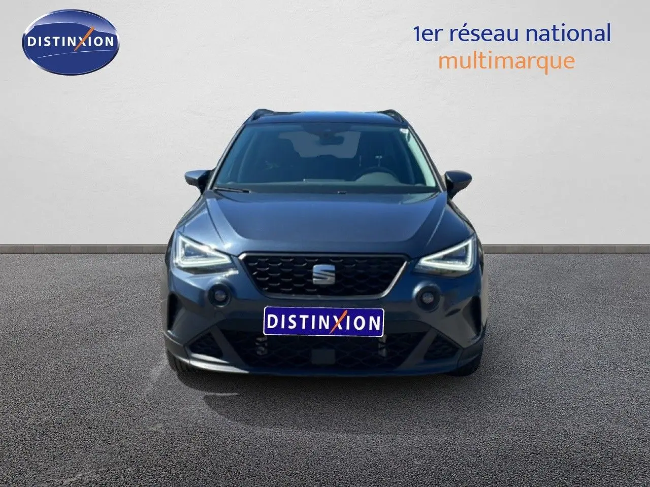 Vue avant d'un SEAT Arona 2025 gris Magnetic Metal avec toit noir, phares LED allumés sur fond neutre.