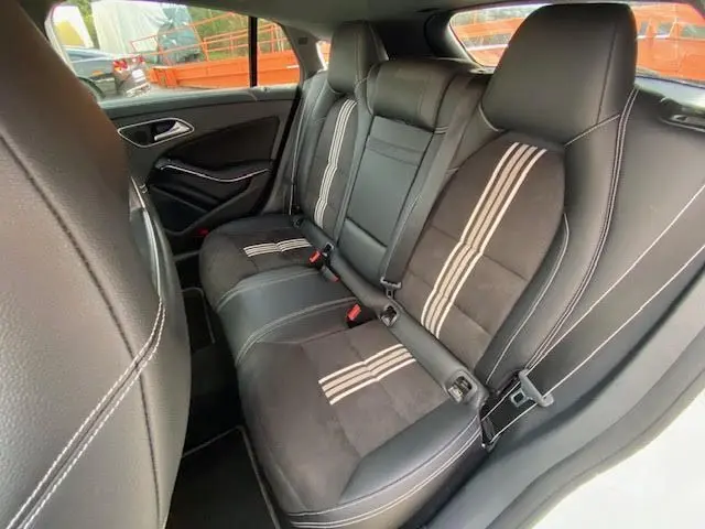 Vue intérieure arrière droite des sièges en cuir noir avec bandes blanches d'une Mercedes CLA Shooting Brake 200D WhiteArt Edition 2017.