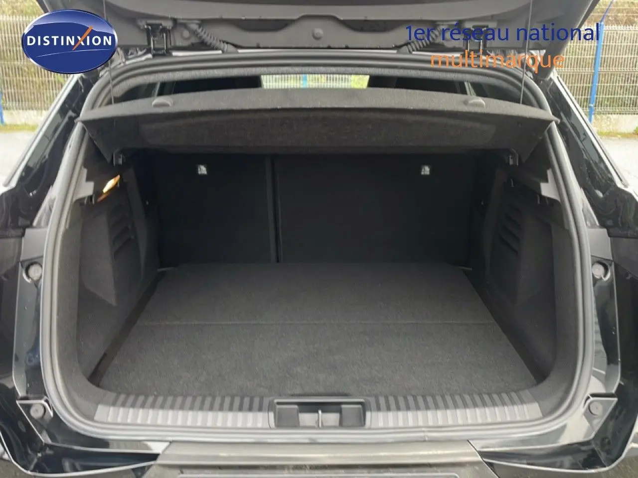 Coffre ouvert vu de l'arrière d'une Renault Symbioz noire étoile métal, espace de chargement vide et propre.