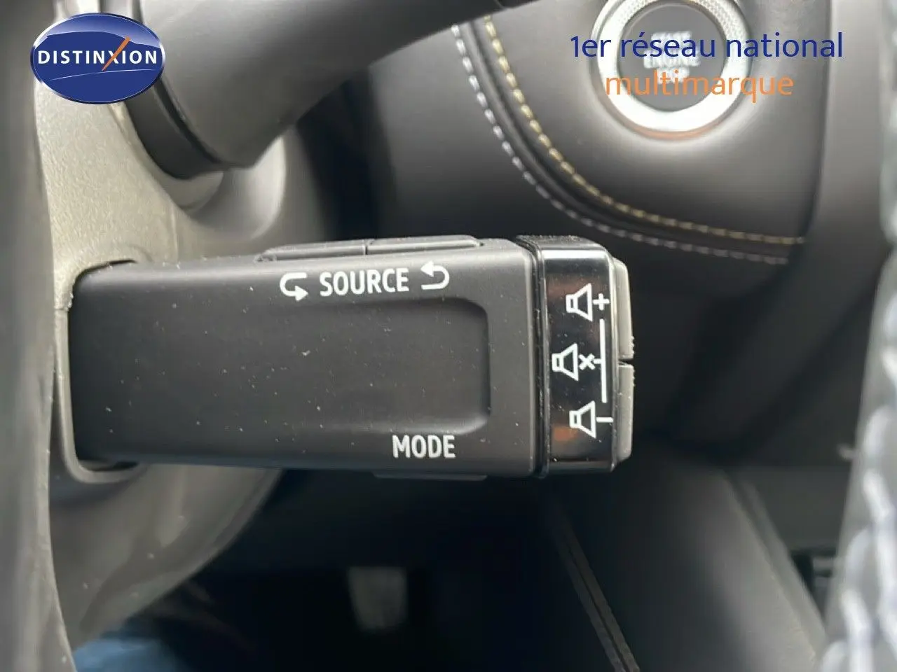 Gros plan sur la commande audio au volant du Renault Symbioz noir étoile métal, avec boutons source et mode visibles.