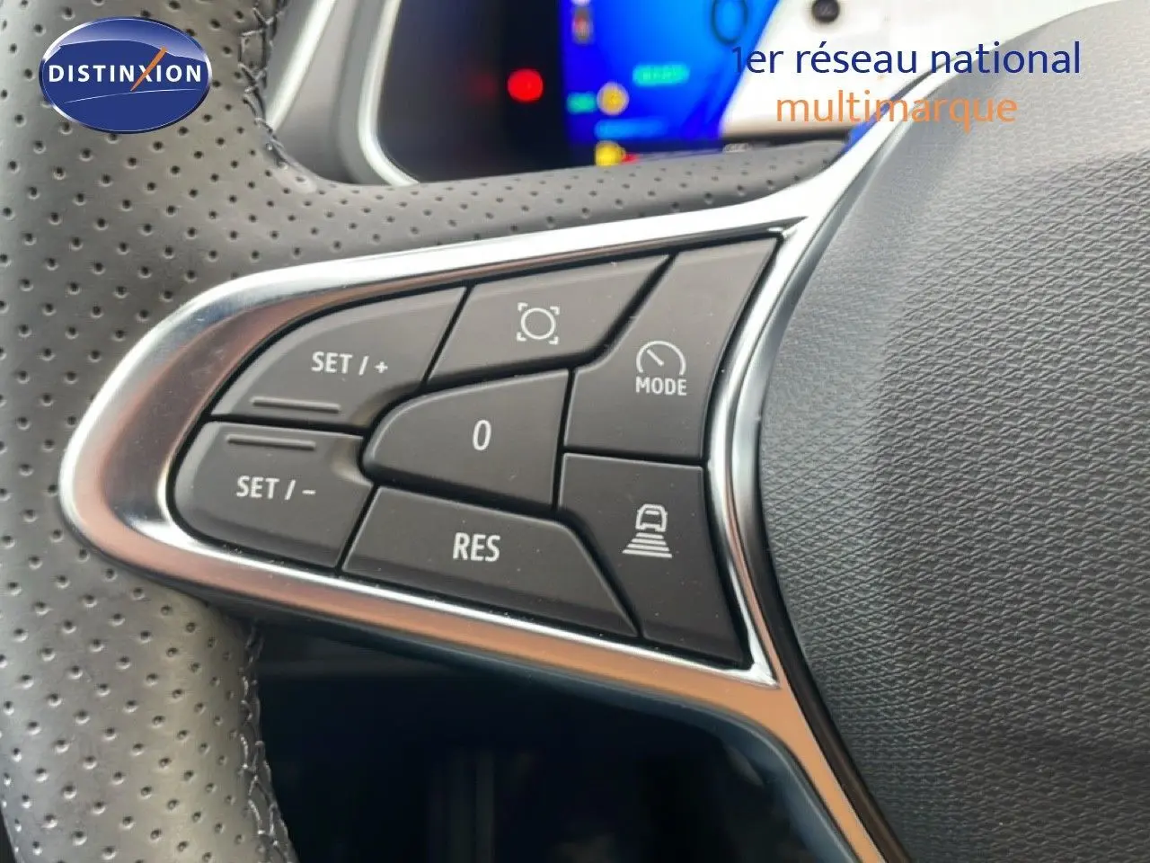 Gros plan sur les commandes au volant en cuir perforé noir du Renault Symbioz 2025, boutons de régulateur de vitesse visibles.