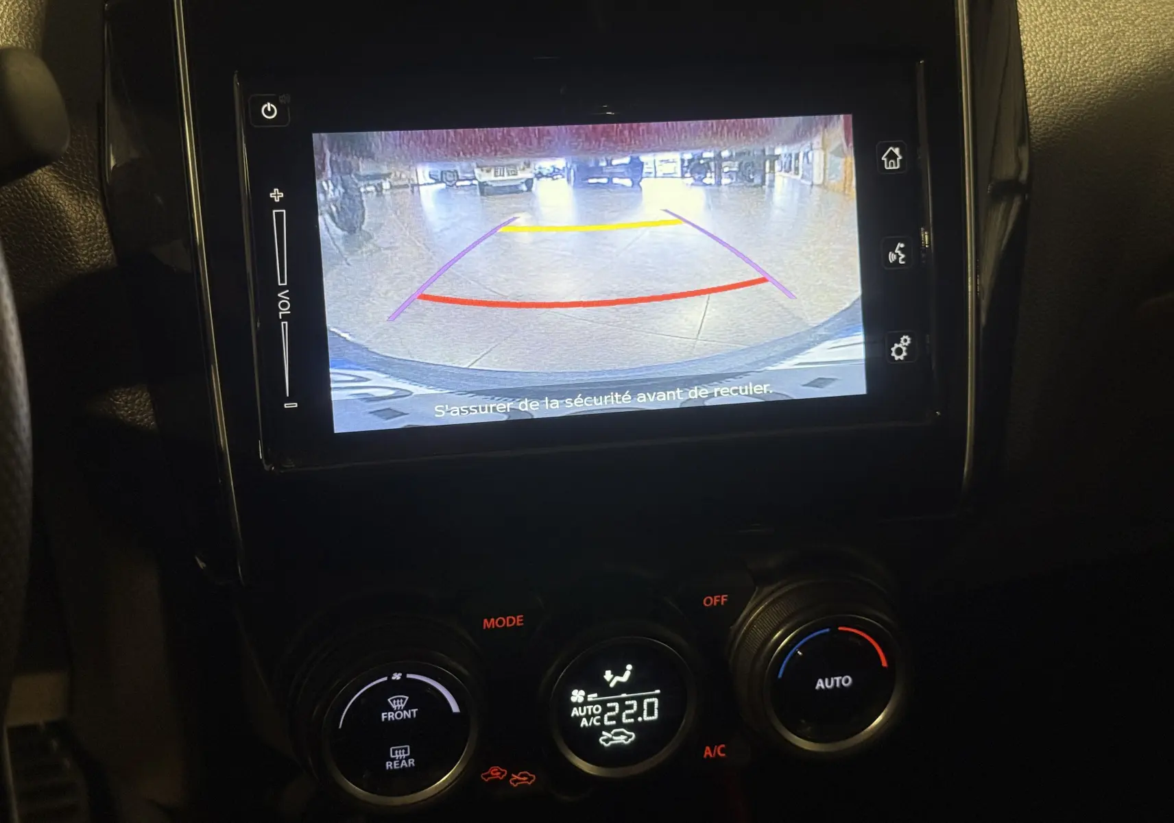 Écran de caméra de recul affiché sur le tableau de bord d’une Suzuki Swift Sport rouge, vue intérieure centrée.