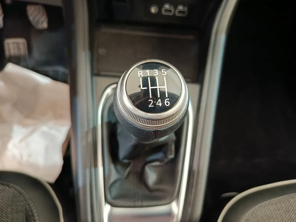Gros plan sur le levier de vitesses manuel du Renault Captur gris foncé, avec indication des 6 rapports et marche arrière.