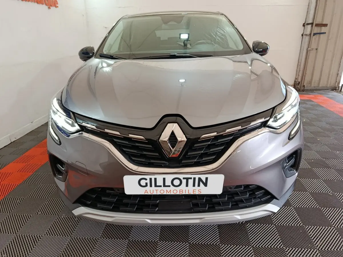 Vue avant rapprochée d’un Renault Captur Techno TCe 90 gris foncé avec feux LED allumés en intérieur.