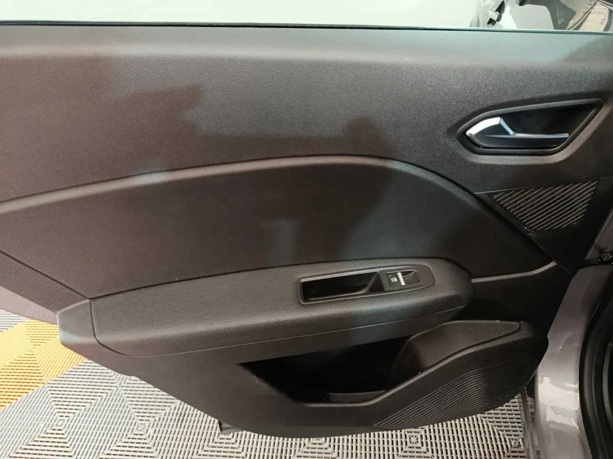 Vue intérieure du panneau de porte avant droit gris foncé du Renault Captur 2024 avec commande de vitre électrique.