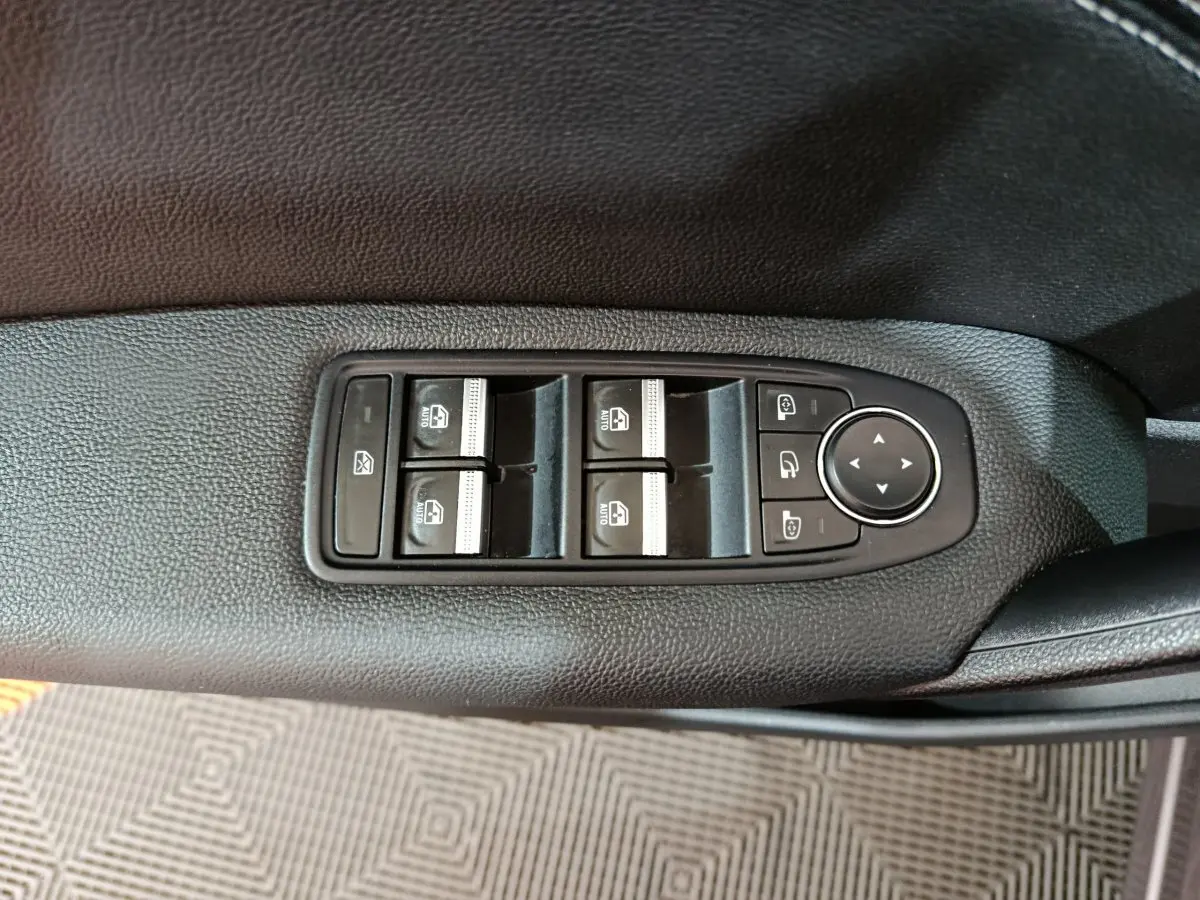 Vue rapprochée des commandes des vitres électriques et des rétroviseurs sur la porte conducteur d’un Renault Captur 2024.