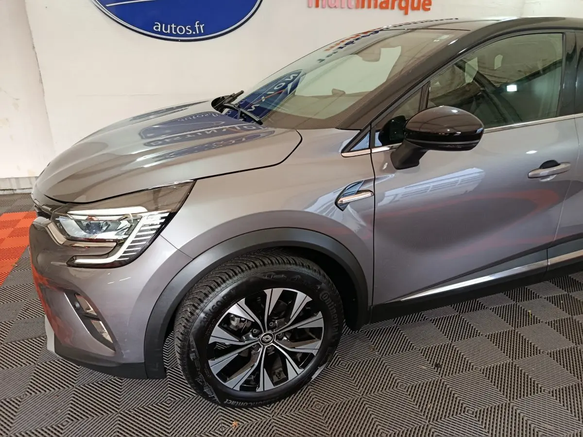 Vue 3/4 avant droit du Renault Captur 2024 gris foncé avec jantes alliage et feux LED distinctifs.