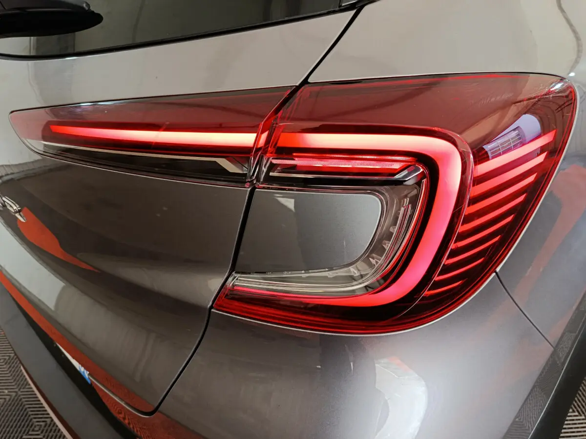 Gros plan sur le feu arrière droit allumé du Renault Captur 2024 gris foncé, soulignant son design moderne et lumineux.