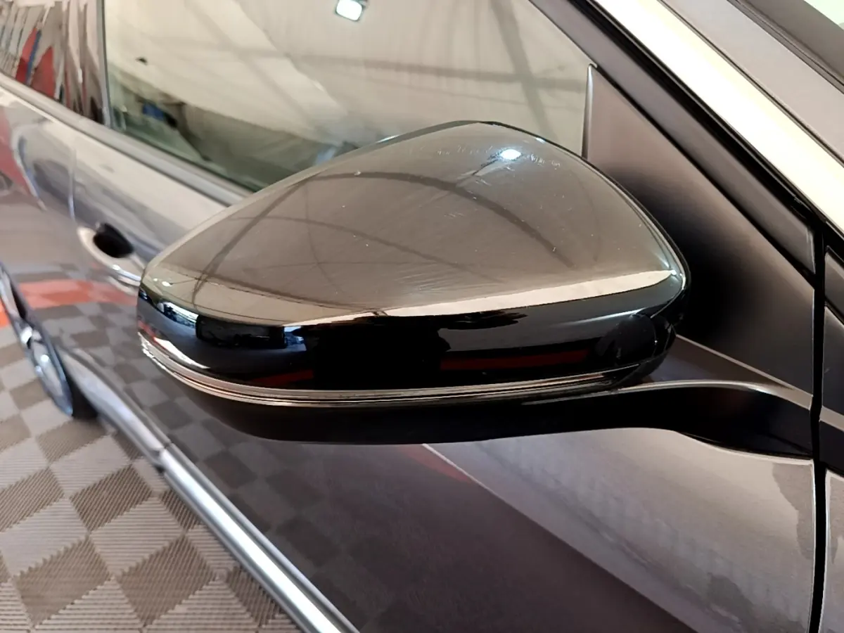 Rétroviseur droit noir brillant du Peugeot 3008 gris foncé, vue rapprochée sur la portière côté droit.