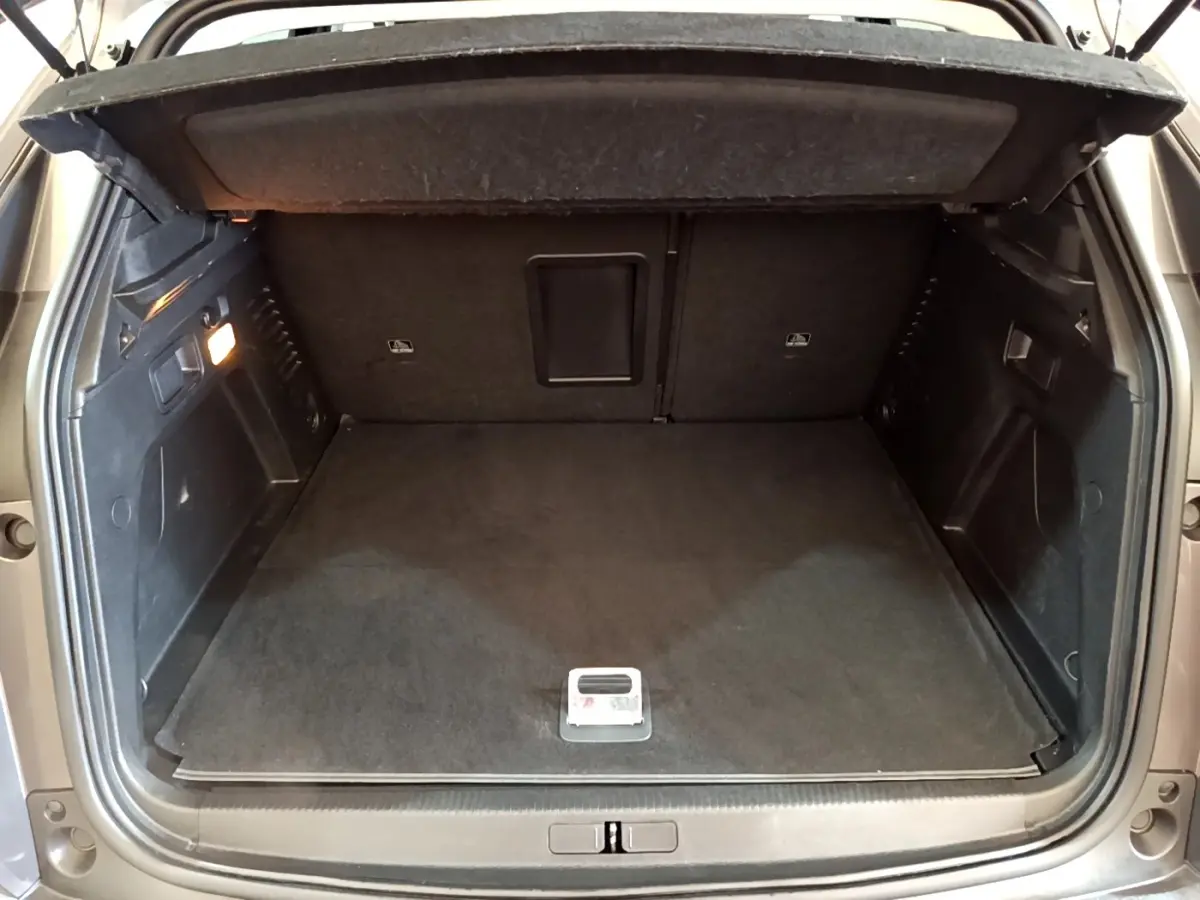 Coffre ouvert du Peugeot 3008 gris foncé, vue arrière, espace de chargement propre et bien éclairé.