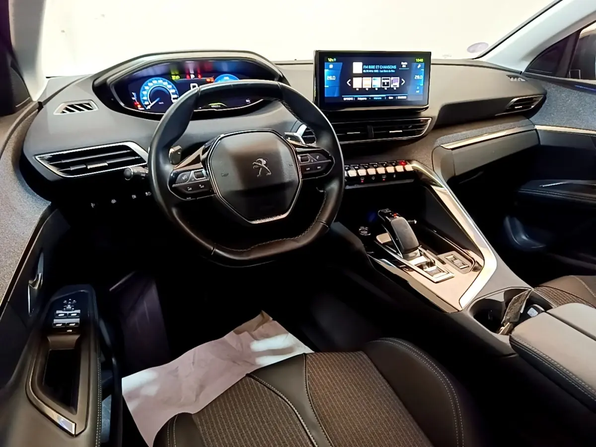 Vue intérieure côté conducteur du Peugeot 3008 hybride 2022, tableau de bord numérique et écran tactile central.