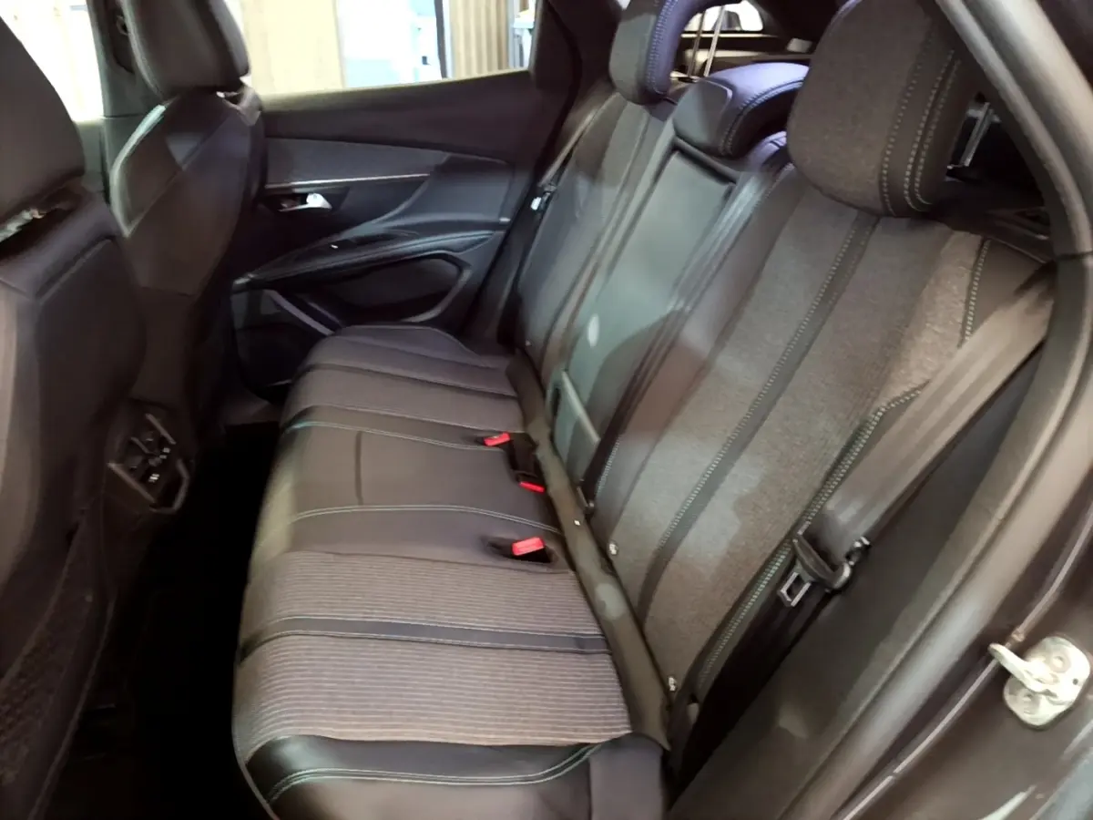 Vue intérieure côté droit des sièges arrière gris foncé du Peugeot 3008 hybride rechargeable 2022 avec coutures contrastées.