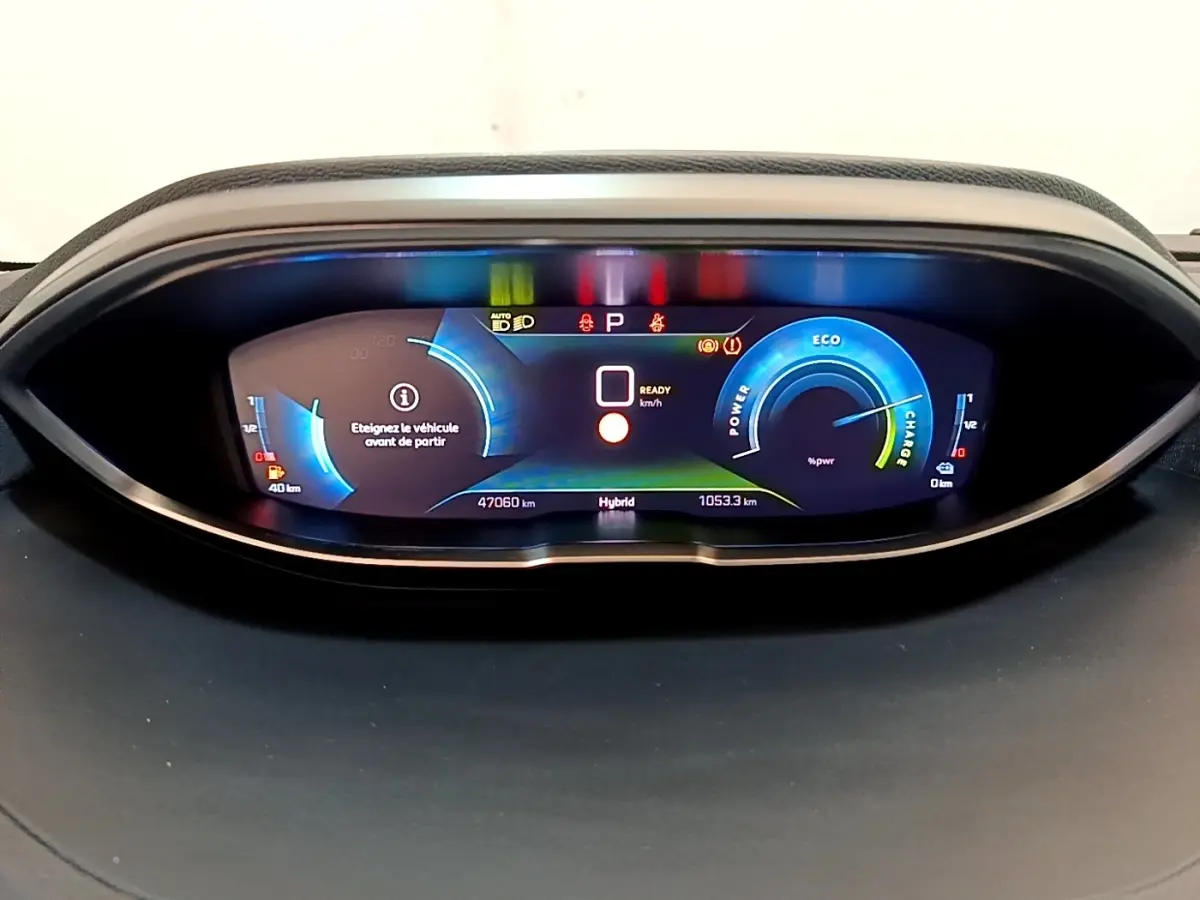 Tableau de bord numérique du Peugeot 3008 hybride, affichage couleur avec indicateurs de puissance et autonomie.
