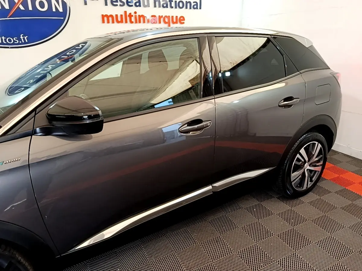 Vue latérale droite du Peugeot 3008 gris foncé hybride rechargeable, avec détails chromés et rétroviseur noir brillant.