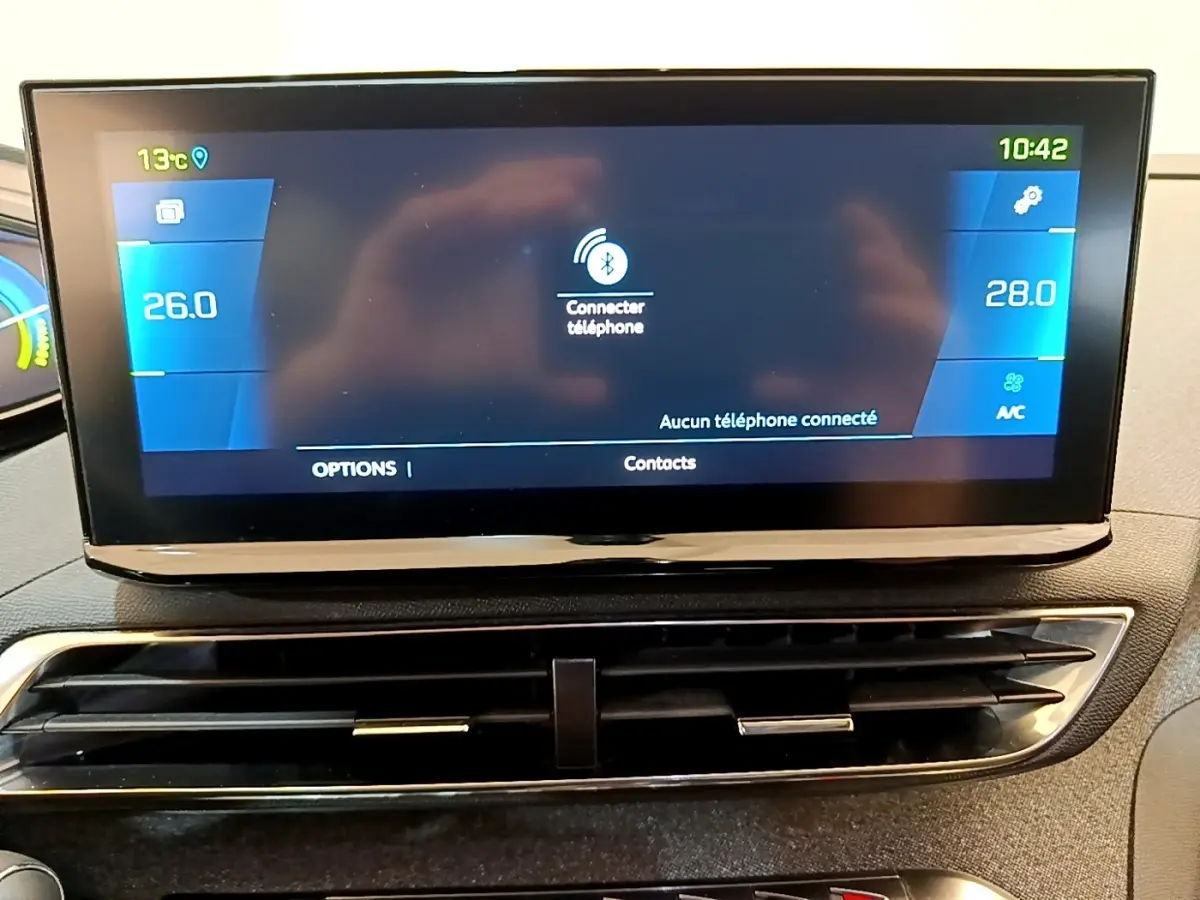 Écran tactile central du tableau de bord du Peugeot 3008 gris foncé, affichant la climatisation et la connexion Bluetooth.