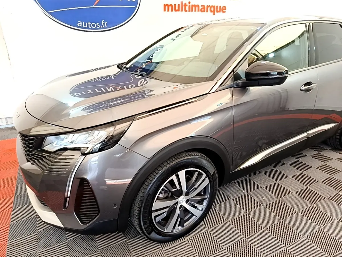 Peugeot 3008 hybride gris foncé en 3/4 avant droit, avec jantes alliage et phares LED allumés.