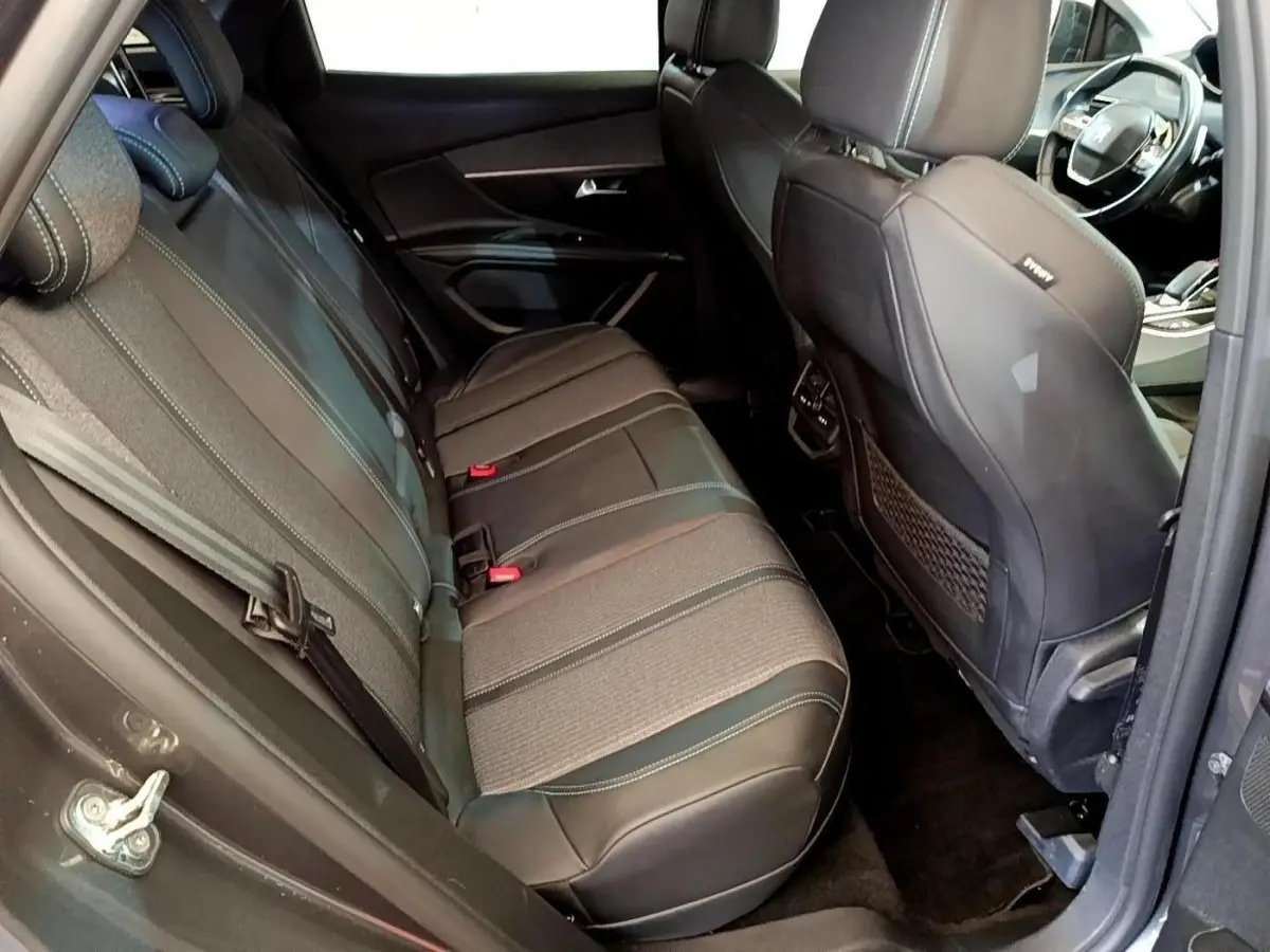 Vue intérieure côté gauche montrant la banquette arrière en tissu et cuir gris du Peugeot 3008 hybride 2022.