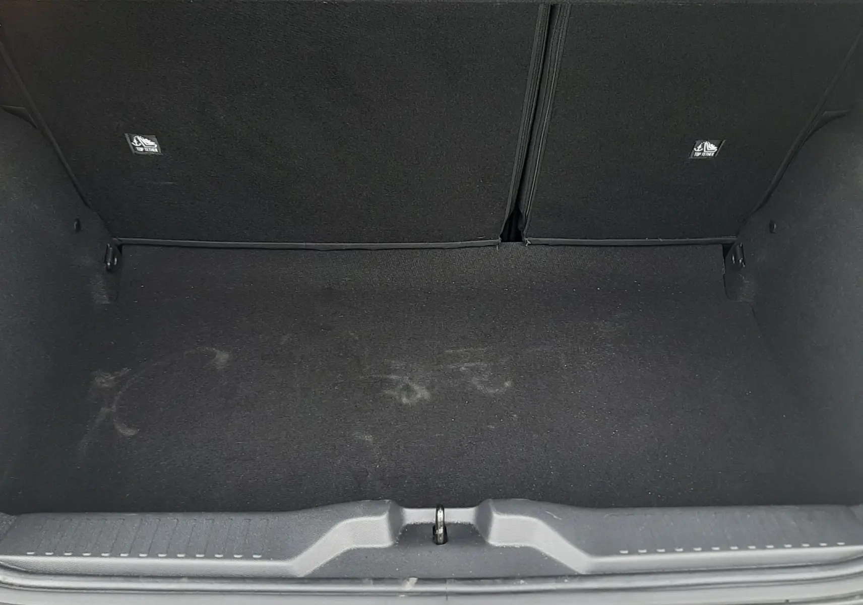 Coffre ouvert vu de dessus d'une Citroën C3 2025 noir perla avec intérieur de coffre noir et banquette arrière blanche.