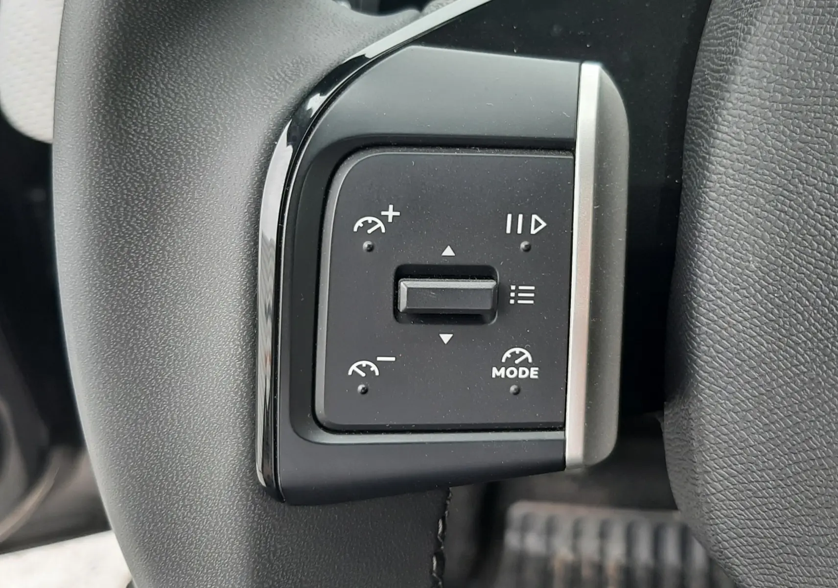 Gros plan sur les commandes du volant côté gauche de la Citroën C3 2025 noir perla avec toit blanc.