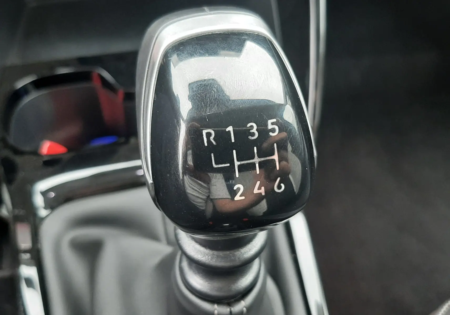 Le levier de vitesses manuel noir brillant de la Citroën C3 1.2 Turbo 100ch Max, avec marquages blancs visibles.