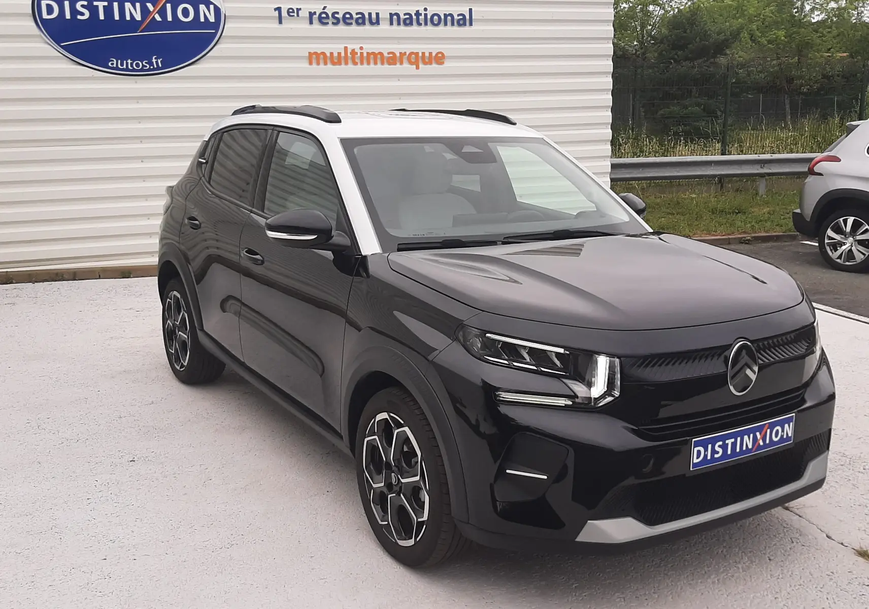 Citroën C3 1.2 Turbo 100ch Max noir perla avec toit blanc, vue 3/4 avant droit sur parking extérieur.