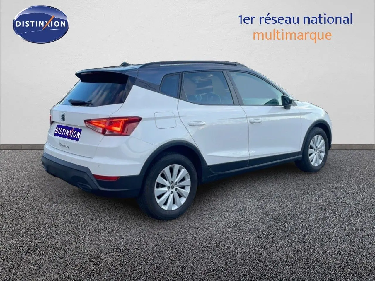 SEAT Arona 2025 blanc avec toit gris, vue 3/4 arrière côté droit, jantes alliage et feux arrière LED visibles.