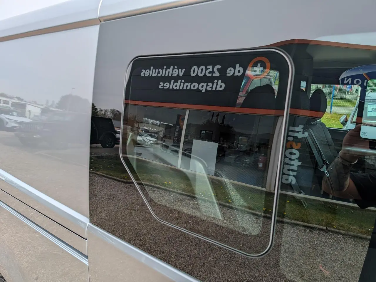 Vue latérale gauche rapprochée du Renault Trafic Fourgon gris Highland, mettant en valeur la vitre ouvrante coulissante.