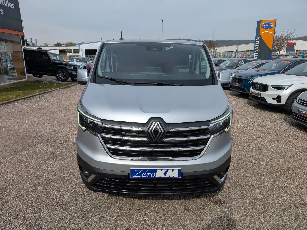 Vue de face du Renault Trafic Fourgon gris avec calandre chromée et feux LED en forme de C.