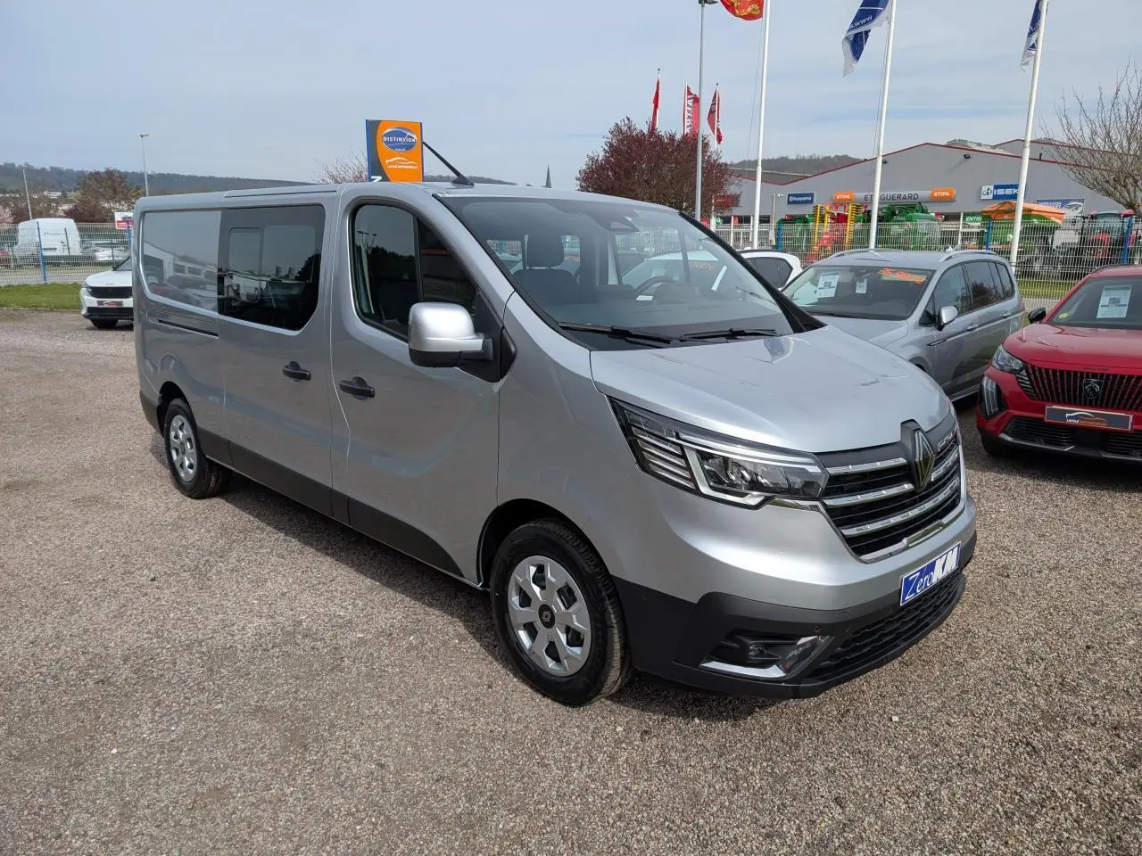 Renault Trafic Fourgon gris Highland en 3/4 avant droit, avec calandre chromée et enjoliveurs 16 pouces.