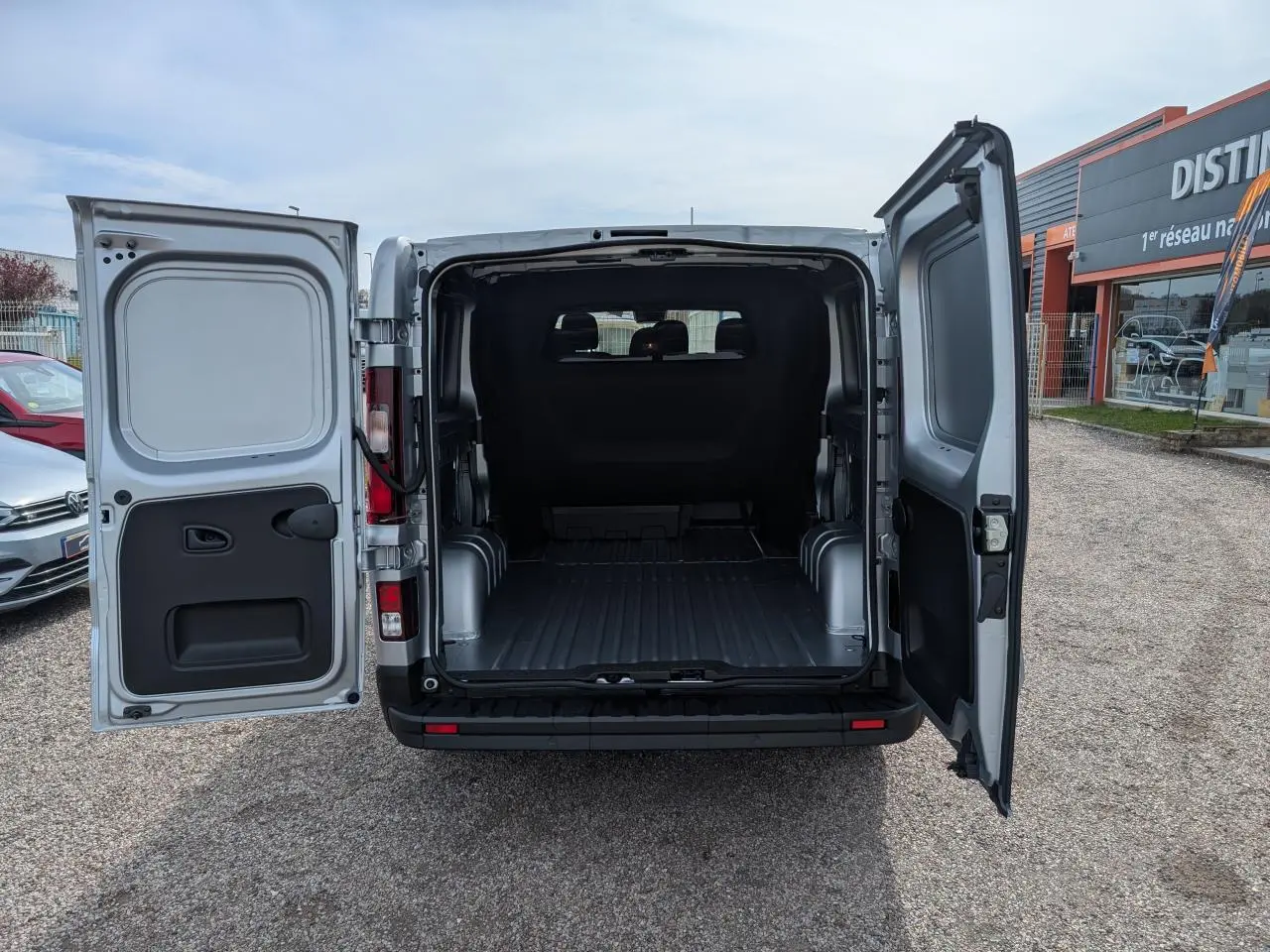 Vue arrière du Renault Trafic Fourgon gris 2025 avec portes ouvertes montrant l'espace de chargement vide.