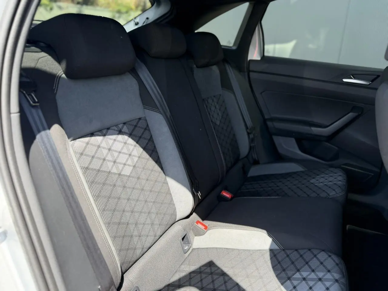 Vue intérieure de la banquette arrière du Volkswagen Taigo TSI 116 DSG R-Line, sellerie tissu noir et gris avec motifs géométriques.