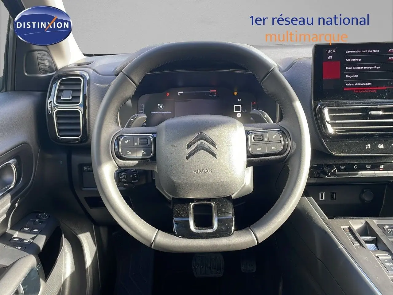 Vue centrée sur le volant cuir du Citroën C5 Aircross 2025, avec tableau de bord numérique et écran tactile.