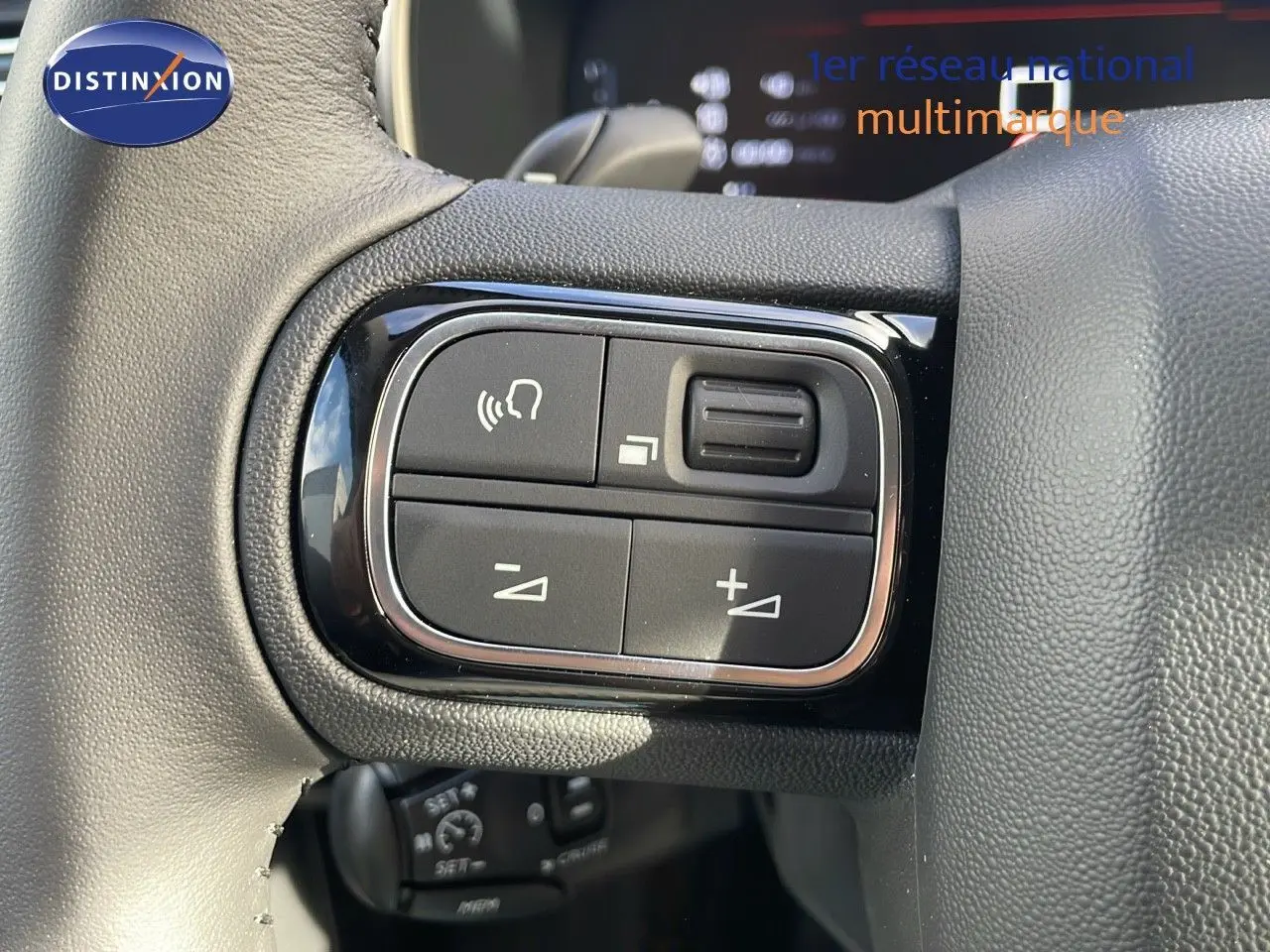 Gros plan sur les commandes de volume et appel au volant en cuir noir du Citroën C5 Aircross bleu Eclipse Metal 2025.