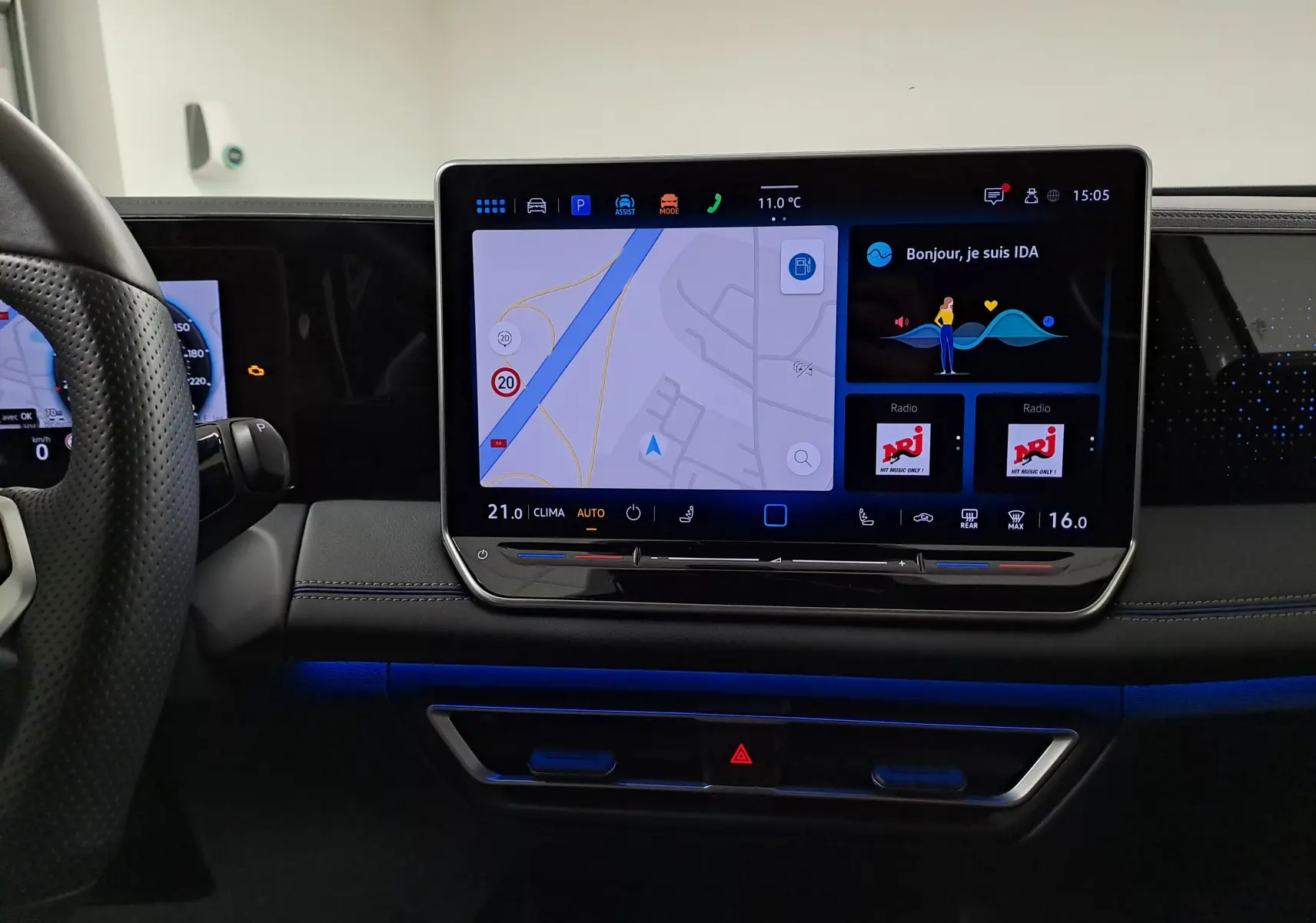 Vue intérieure du tableau de bord du Volkswagen Tiguan 2025 avec écran tactile central affichant navigation et radio NRJ.