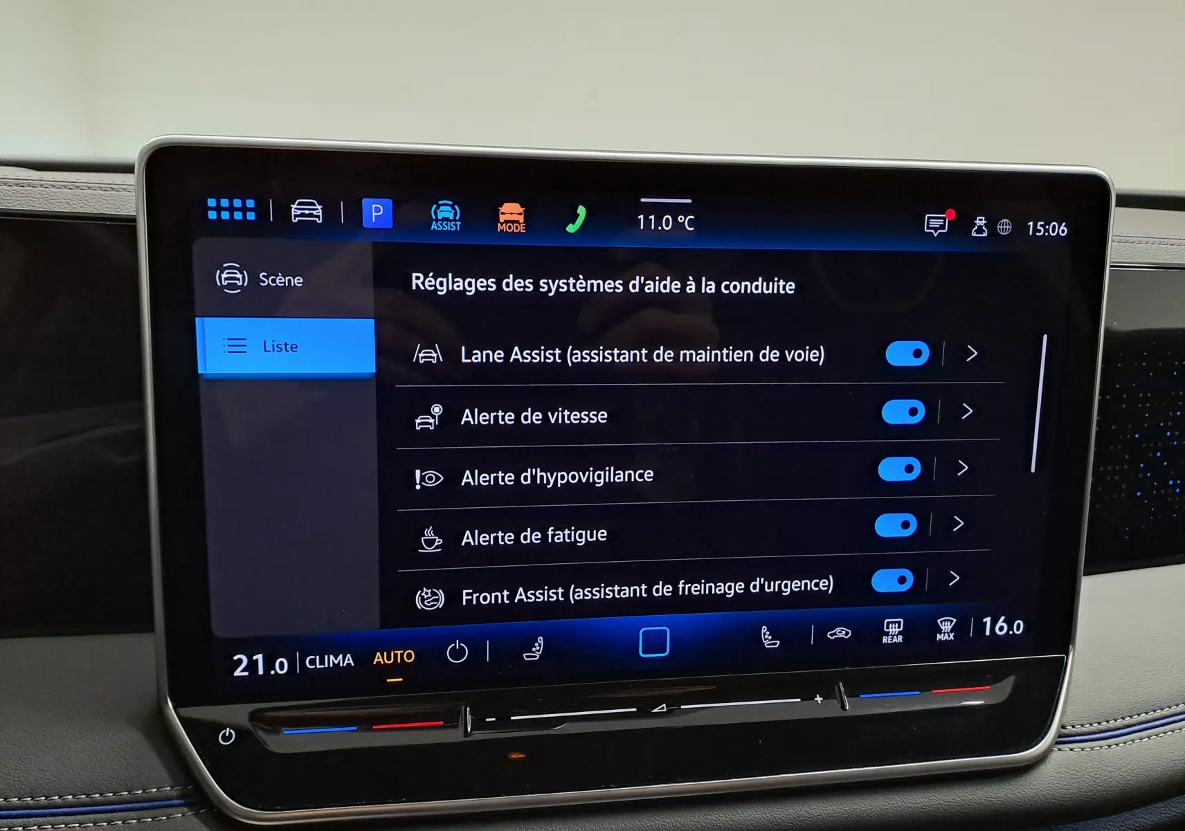Écran tactile central du Volkswagen Tiguan 2025 affichant les réglages des aides à la conduite, intérieur avec surpiqûres bleues.