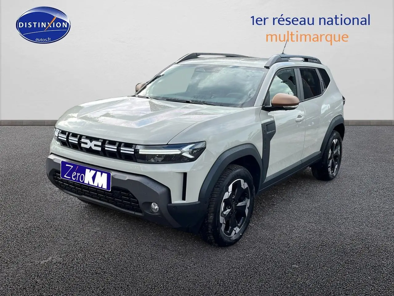 Vue 3/4 avant du Dacia Duster 2025 couleur Sandstone avec barres de toit et jantes alu noires.
