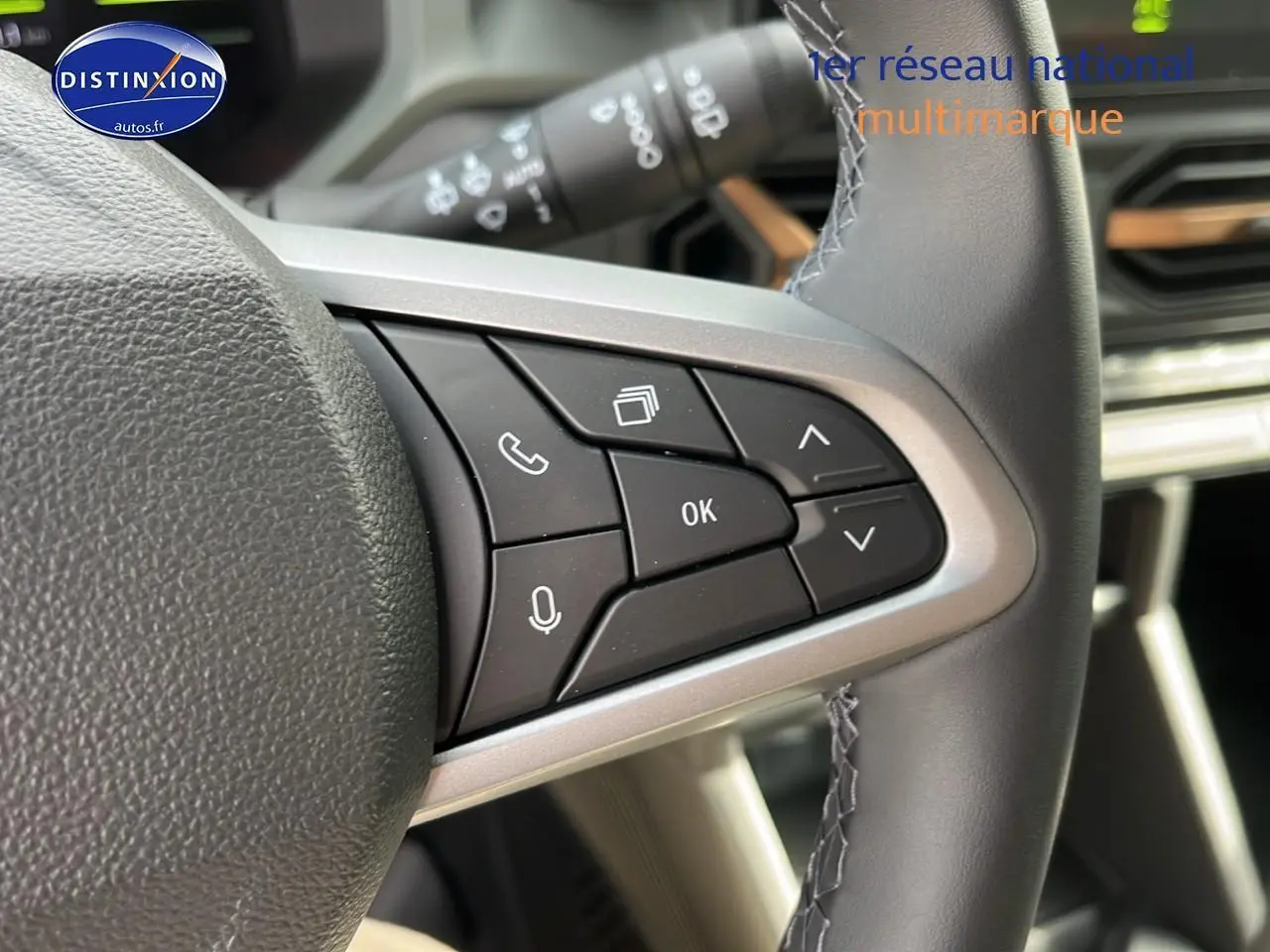 Gros plan sur les commandes multifonctions à droite du volant du Dacia Duster 2025 couleur Sandstone.
