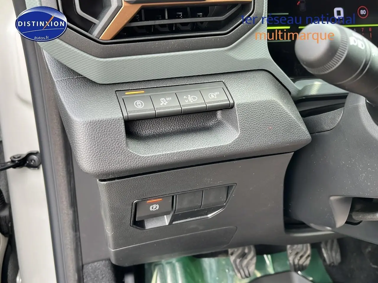 Détail des commandes sous le tableau de bord côté gauche du Dacia Duster 2025 couleur Sandstone.