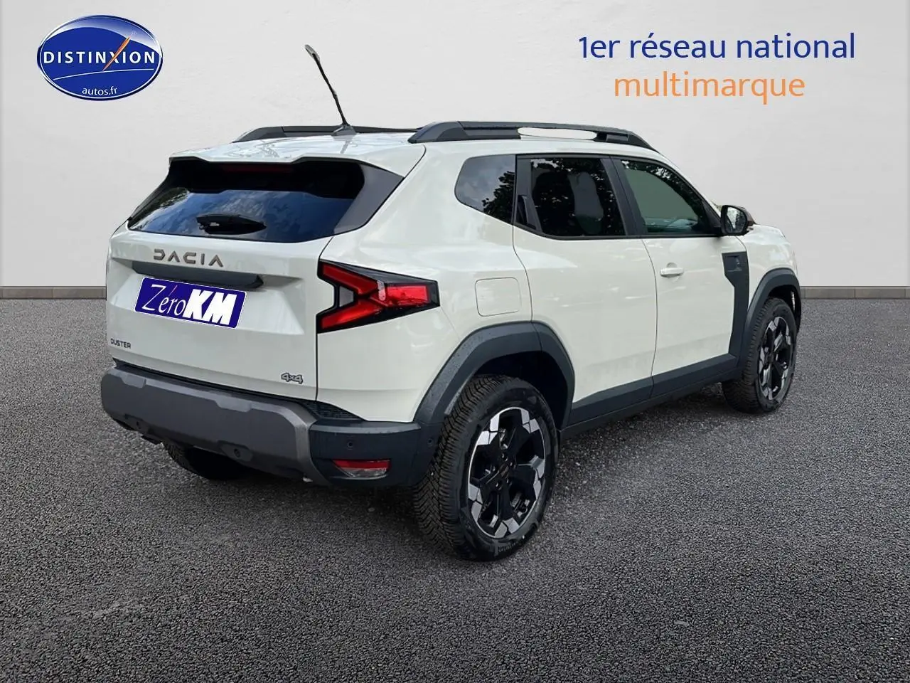 Vue 3/4 arrière droite du Dacia Duster 2025 couleur Sandstone avec jantes alu et barres de toit noires.
