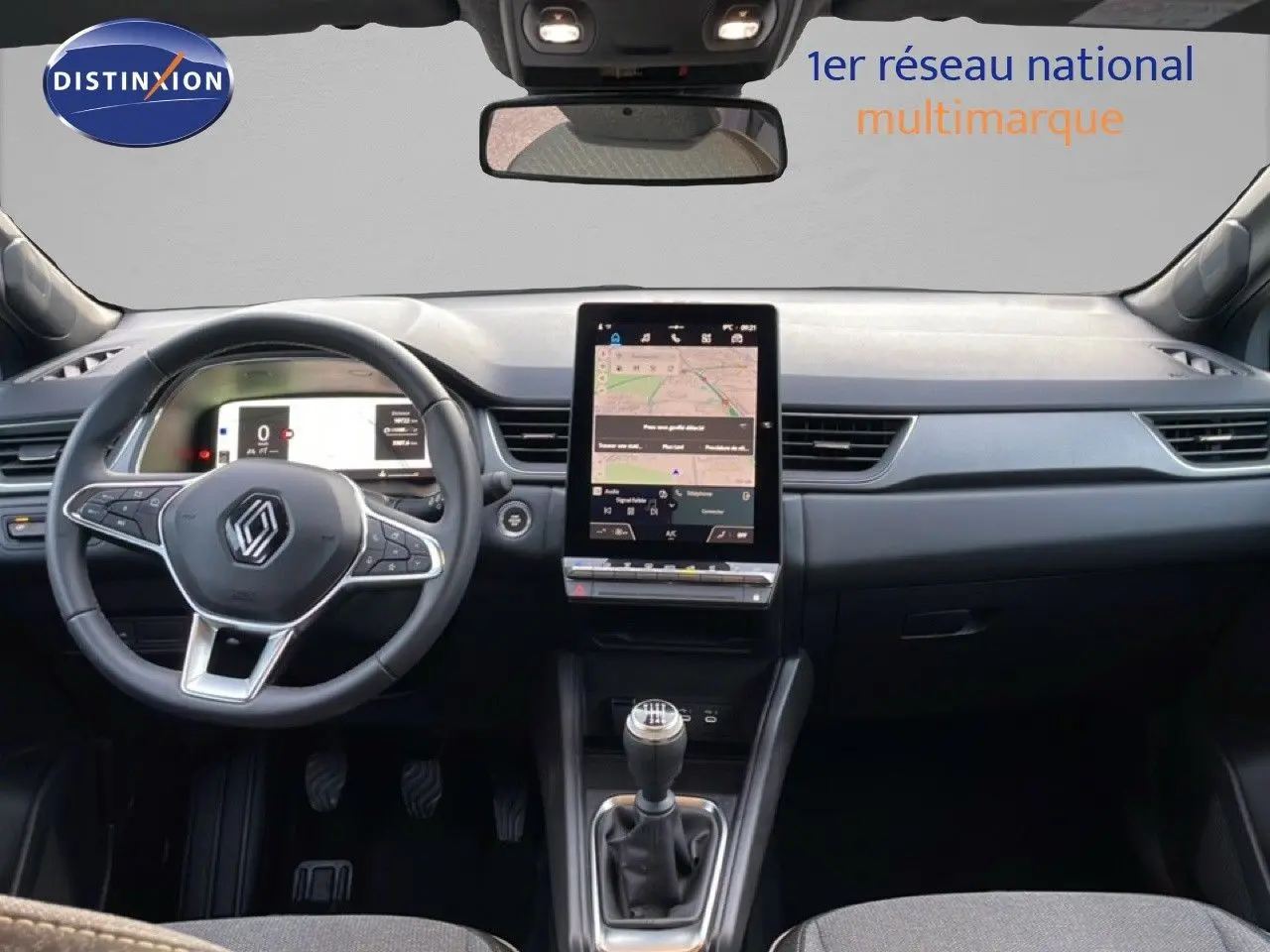 Vue intérieure frontale du tableau de bord du Renault Captur gris Rafale métal avec écran tactile vertical et boîte manuelle.