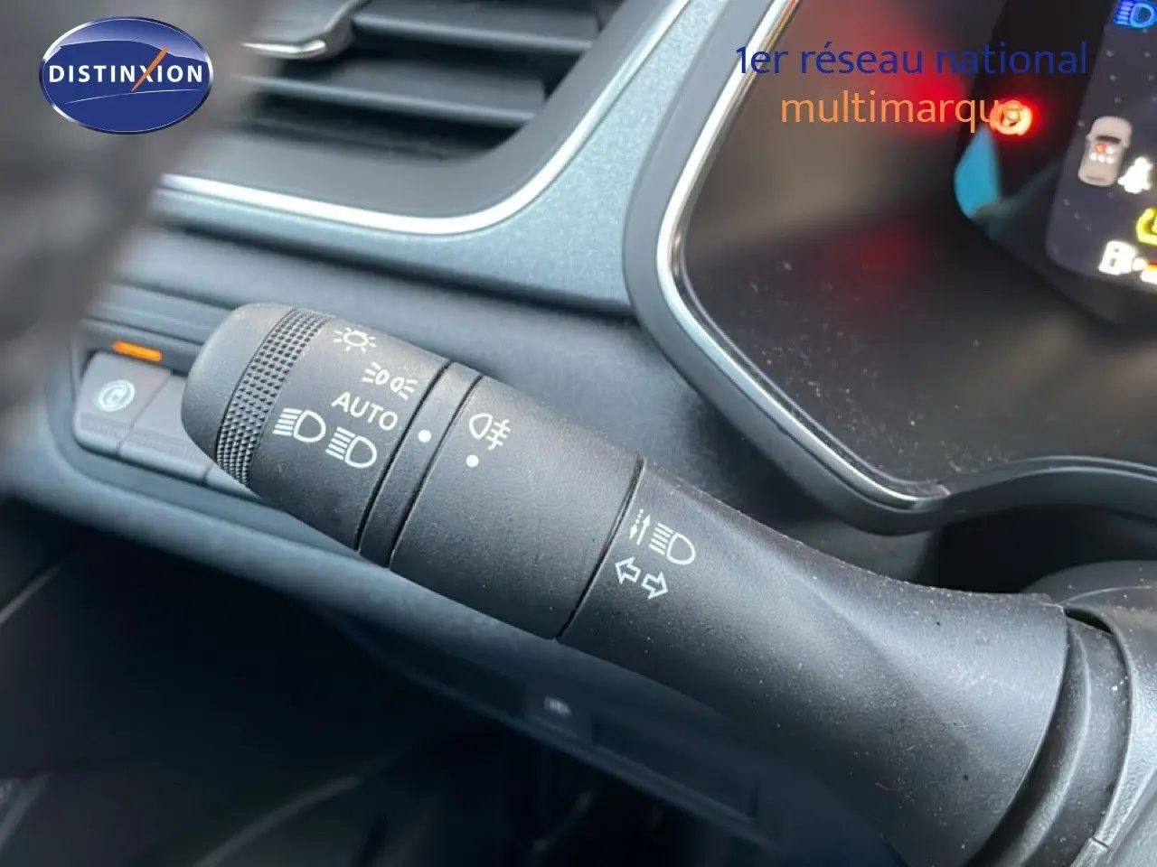 Gros plan sur la manette de commande des phares et clignotants dans l'habitacle du Renault Captur gris Rafale Métal.