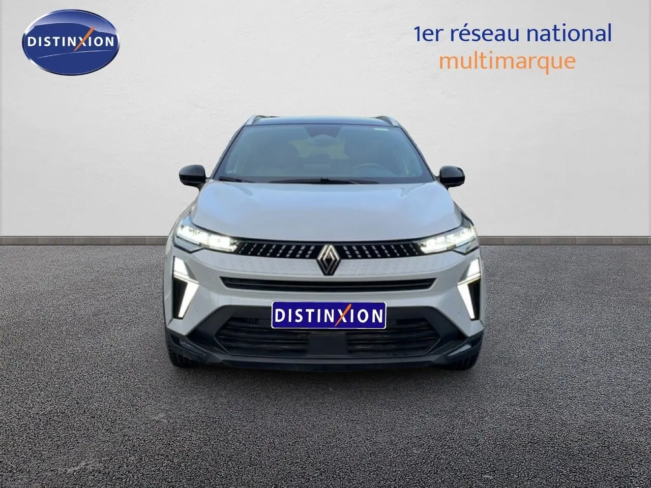 Vue avant d'un Renault Captur 1.0 ECO-G 100ch Techno gris Rafale métal avec toit noir, feux LED allumés.